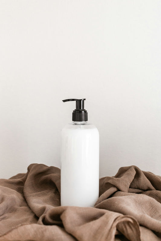 white plastic bottle on white table